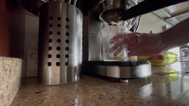 Preparando caf&eacute; caliente de m&aacute;quina antioxidante y estimulante para despertar en vaso de cristal en la cafetera el&eacute;ctrica sobre la encimera de la cocina de casa