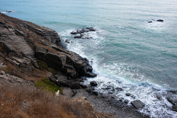 Rocky coastline with crashing waves and serene ocean view, showcasing natural textures and colors, perfect for environmental themes and coastal landscapes