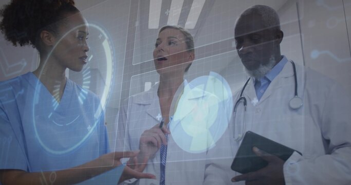 Pointing scrub nurse and labcoat doctors analyzing digital display in ward with tablet stethoscope