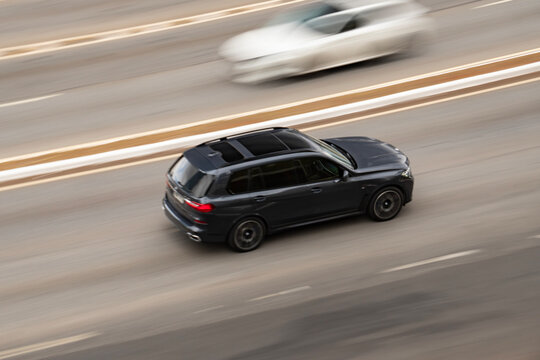 Black BMW X7 in motion, High angle panning shot, luxury SUV on highway