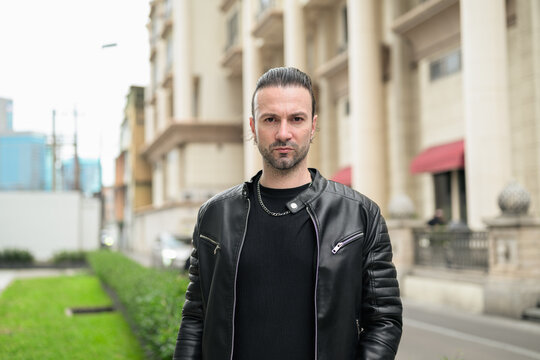 Fototapeta Handsome bearded man in black leather jacket posing in city streets