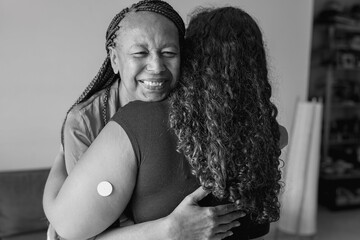 Happy african mother hugging daugher with diabetes patch at home - Family love, lifestyle and...