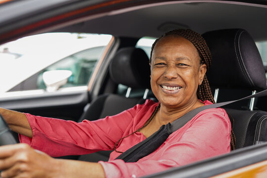 Happy african american senior woman smiling on camera while driving a car - Transportation, independence and elderly person concept - Focus on face