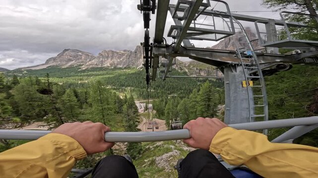 Point of view of traveler riding a cable car near the Cinque Torri in the Dolomites, Italy. Travel adventure in the Alps with scenic mountain landscape and forest