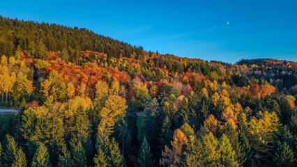 Bunte Herbstlandschaft in den Bergen mit klar blauem Himmel und teilweise bewölkter Sicht