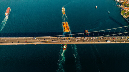 Aerial view of the Bosphorus Bridge with drone on a cloudy day. Tanker ship passing under the FSM Bridge with a heavy car traffic on the bridge.Aerial view of The Second Bosphorus Bridge.