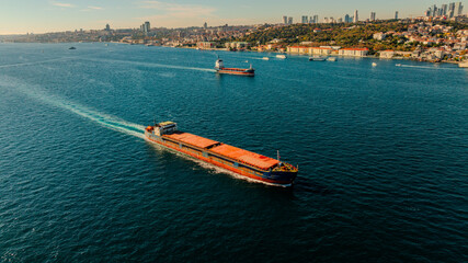Aerial view of the Bosphorus Bridge with drone on a cloudy day. Tanker ship passing under the FSM Bridge with a heavy car traffic on the bridge.Aerial view of The Second Bosphorus Bridge.