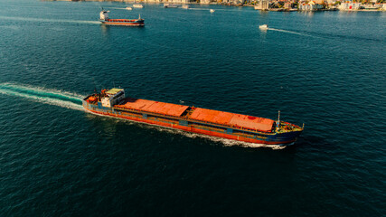 Aerial view of the Bosphorus Bridge with drone on a cloudy day. Tanker ship passing under the FSM Bridge with a heavy car traffic on the bridge.Aerial view of The Second Bosphorus Bridge.