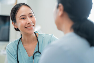 Asian female doctor consults her senior patient with genuine care, while a compassionate nurse...