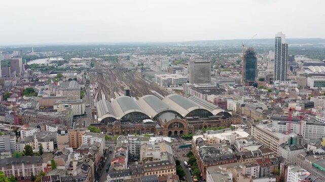 Aerial flyover towards Frankfurt (Main) Hauptbahnhof, highlighting the fusion of historic and modern urban architecture, vibrant European city living, and integrated transport infrastructure.