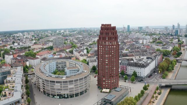 Wide aerial view of a German urban district featuring a distinctive modern tower and circular block, set against traditional city blocks, green avenues, and vibrant contemporary European design.