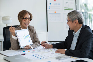Asian business adults discussing financial data presentation strategic planning professional office meeting collaboration project analysis market review
