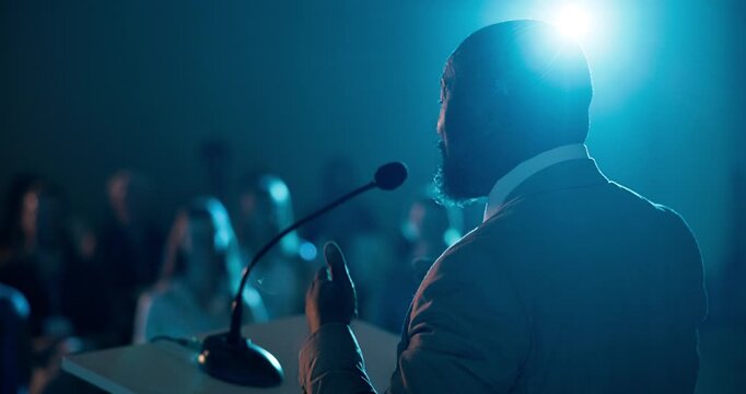 Businessman, podium or meeting with crowd in auditorium for presentation or speech in seminar. Man, employee or speaker with microphone, team or flare for audience, business workshop or trade show