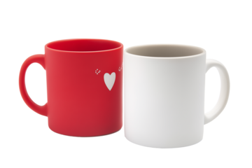 Two ceramic mugs, one red with white heart and dotted pattern, one plain white, isolated on transparent background