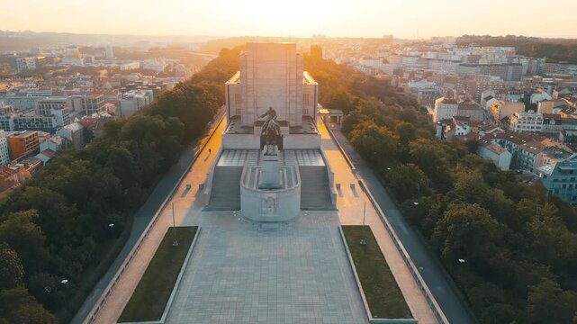 Witness the stunning Vitkov National Monument in Prague during sunrise. The view highlights the grand equestrian statue of Jan Zizka on the hill, surrounded by beautiful scenery.