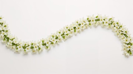 Flower garland arrangement with white flowers on a plain white background.