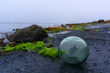 Mysterious glass orb shimmering on a quiet Russian shore at dusk