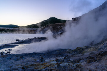 Steam rises from volcanic landscape in Russia during twilight hours