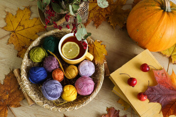 Autumn days for my favorite craft: colorful skeins of yarn against a backdrop of books and a yellow mug of tea, viewed from above