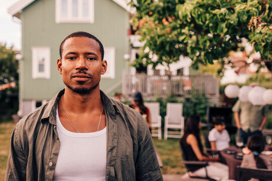 Portrait of man with shaved head in back yard party