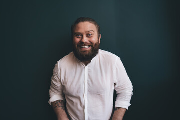 Fototapeta premium Bearded man smiling widely, leaning forward