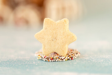 Star-shaped anise cookie on colorful chocolate sprinkle background