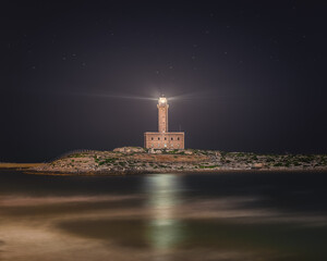 Isolated Vieste Lighthouse Illuminated at Night with Starry Sky