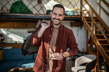 Happy man traveling home smiling carrying luggage