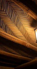 Woven thatch ceiling and hanging lantern in dim light