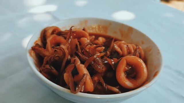 A bowl of squid in sweet and sour sauce. Seafood typical of Asian cuisine. Footage.