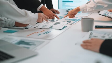 A professional team engages in a data analysis meeting, surrounded by charts and graphs, laptops, and coffee, emphasizing collaboration and strategic planning. SACTR - Powered by Adobe