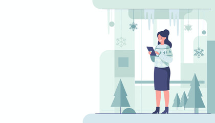 Happy woman using tablet by a window decorated for winter surrounded by snow and pines