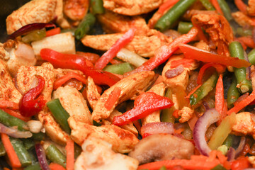 Vegetables with meat are fried in a frying pan