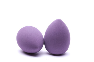 Makeup egg blenders of purple color on white background. Beauty concept.