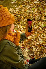 Girl playing with fallen autumn leaves.