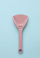 Children's plastic shovel for sandbox on blue background