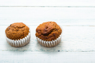 pair of chocolate muffins on white table
