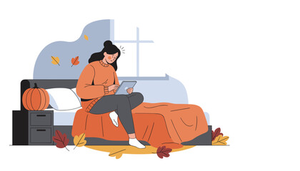 Sad woman uses a tablet in her cozy autumn bedroom struggling with depression or online stress