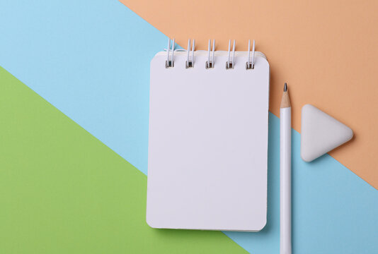 Notepad with school stationery supplies on pink blue background - Powered by Adobe