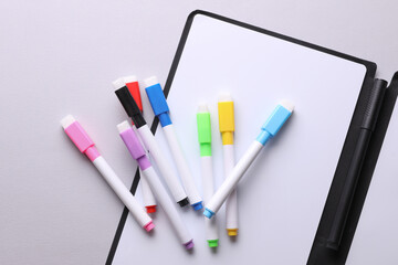 Colored markers with white board for drawing on gray background