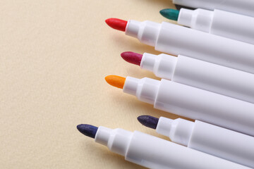 Set of colored markers on pastel background