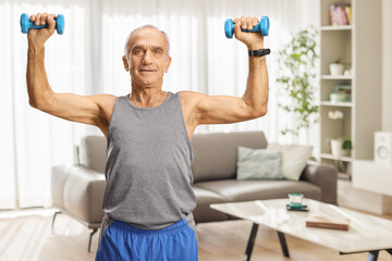 Fit elderly man exercising with dumbbells