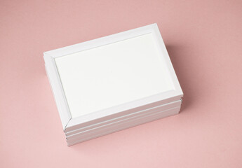 Stack of white photo frames on pink background