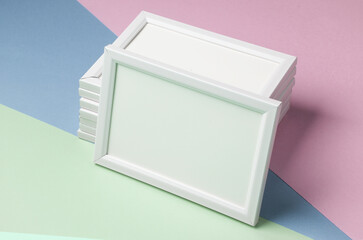 Stack of white photo frames on colorful pastel background