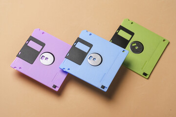 Floating colored retro 80s floppy disks on yellow background. Conceptual pop, creative layout