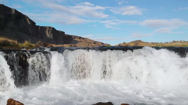 Aerial of waterfall on river at the foot of cliffs