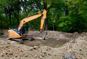 Backhoe leveling sand that has been laid as the bottom level of a septic system drain field