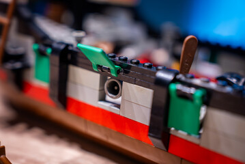 Macro view of LEGO ship hull with red stripe and green gunports