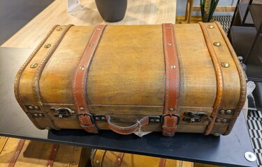 Maleta de madera con asas y correas de cuero en mesa de exposición de comercio 
