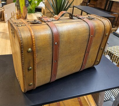 Maleta de madera con asas y correas de cuero en mesa de exposici&oacute;n de comercio
